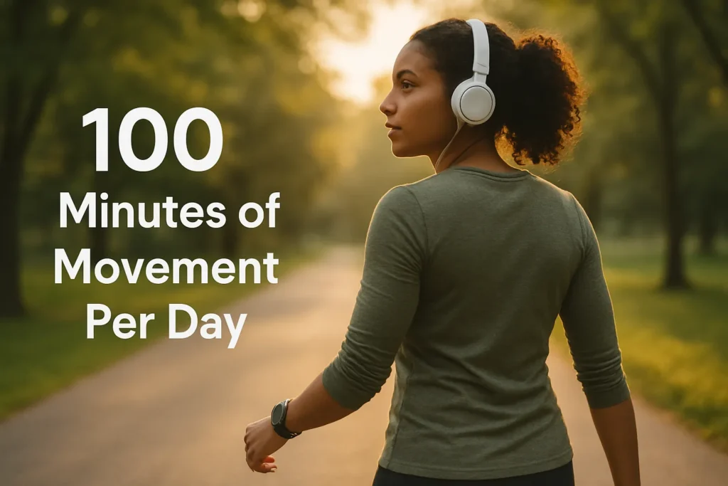 Person walking through park or trail with headphones in, fitness watch visible, overlay text- 100 Minutes of Movement Per Day